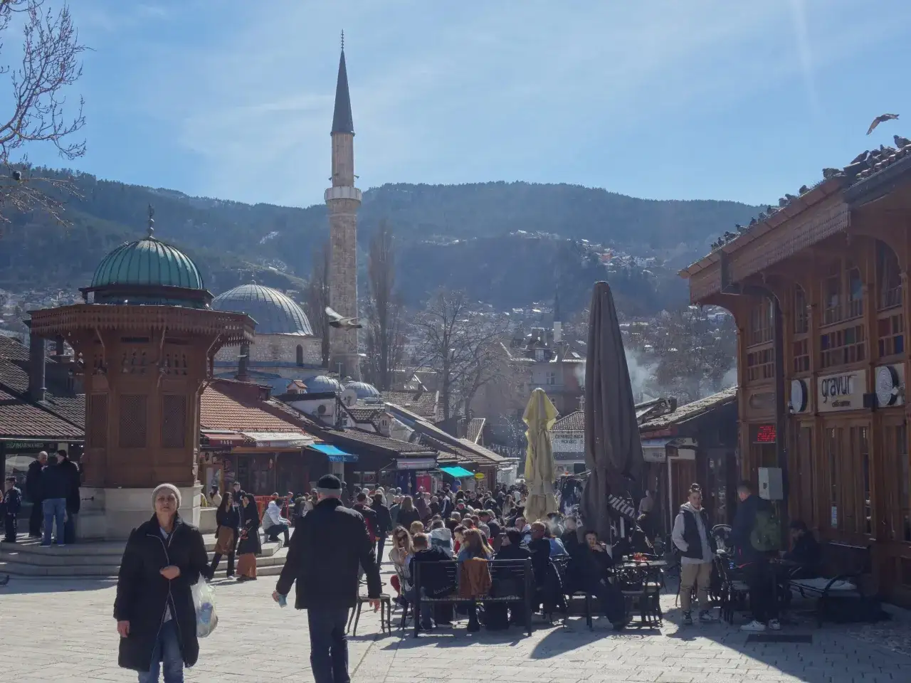 Tętniący życiem plac w Sarajewie, z minaretem i kopułą meczetu w tle. Idealne miejsce, by poczuć atmosferę miasta i odkryć, co zobaczyć w Sarajewie.